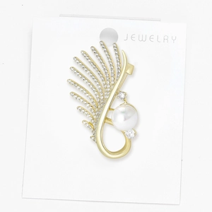 Detail of elegant gold brooch with large white pearl and micro-pave cubic zirconia wing