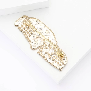 Detailed back view of gold bird brooch showing pin clasp and metallic texture