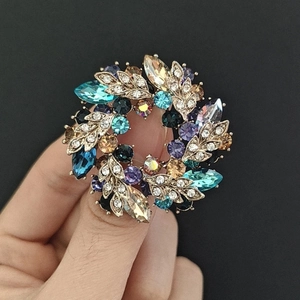 Macro detail of elegant wreath brooch with colorful rhinestones and vintage finish