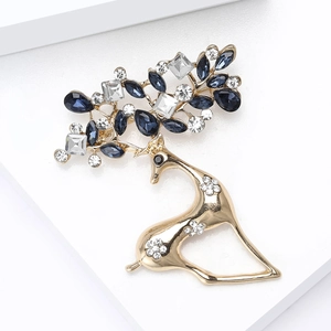 Dettaglio di spilla a forma di cervo dorato con gemme blu scuro e strass brillanti