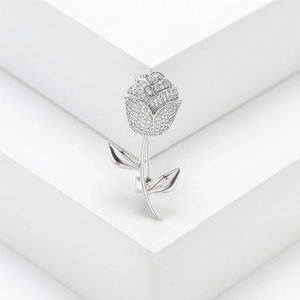 Close-up of elegant silver rose brooch with pavé micro-zirconia on minimalist background