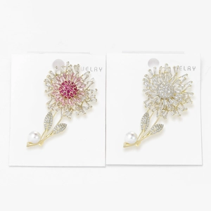 Detail of flower brooches with dandelion crystals, white pearls, and gold finish