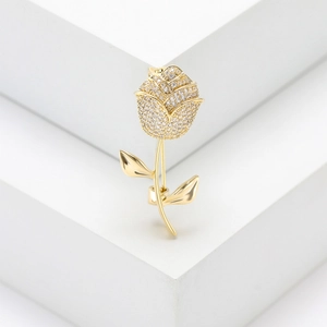 Macro shot of elegant gold rose brooch with micro-pave zircons and mirror-polished finish