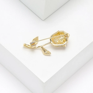 Detail of the golden rose brooch back showing the pin closure and honeycomb structure