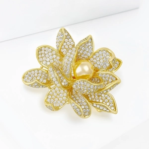 Détail macro de la broche lotus dorée avec zircons micro-pave et perle centrale