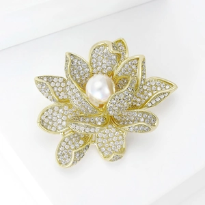 Détail macro d'une broche lotus avec zircons pavés et perle blanche centrale