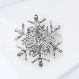 Detailed back view of the silver snowflake brooch showing the secure pin fastener mechanism