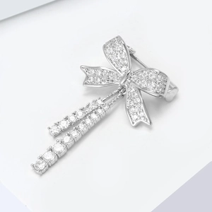 Dettaglio di una spilla a fiocco argento con nappe di zirconi e micro-intarsio scintillante