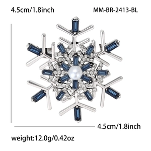 Elegant silver snowflake brooch with blue crystals and a pearl for winter coats