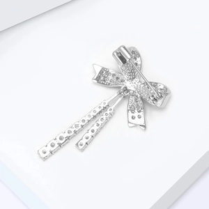 Dettaglio macro del retro di una spilla a fiocco in argento con spilla di sicurezza
