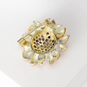 Detail view of the sunflower brooch back with golden textured metal and safety pin buckle