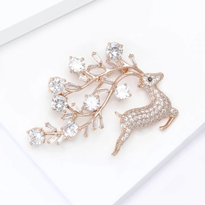Detalle macro de broche de ciervo en oro rosa con microcirconitas y astas de cristal fino