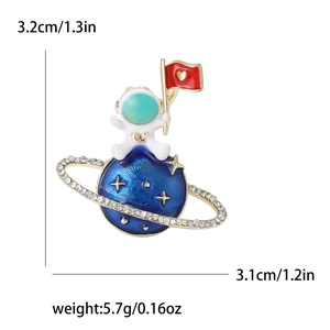 Spilla creativa astronauta su pianeta blu con strass e dimensioni di 3,2cm x 3,1cm