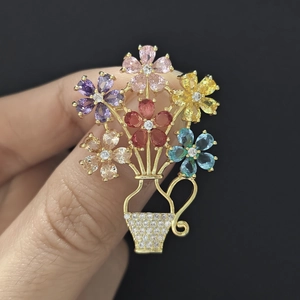 Close-up of a floral basket brooch with colorful zircons on a gold-plated base