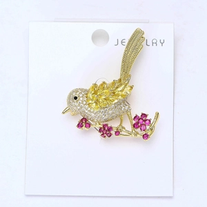 Detailed view of a bird brooch with colorful zircons on a golden floral branch