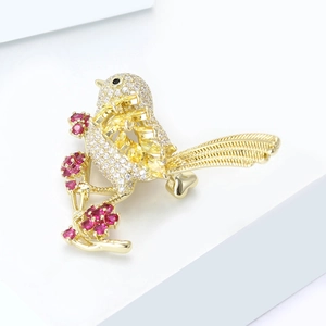 Exquisite gold bird brooch with sparkling zircons and yellow gems on floral branch