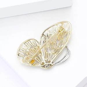 Detail view of double-layer hollow butterfly brooch with gold and silver dual-tone finish