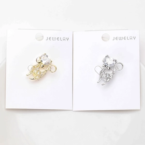 Detail of gold and silver cat pins with heart-shaped crystals and micro zircon inlay