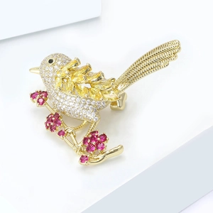 Sparkling bird brooch with colorful zircons and golden plating on white pedestal