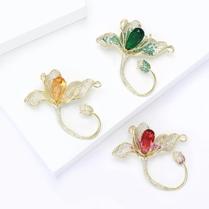 Broches fleurs dorées élégantes avec cristaux émeraude, ambre et rubis sur blocs blancs