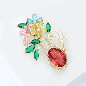 Broche vase élégante dorée sertie de pierres colorées et d'un grand cristal rouge