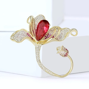 Vue macro d'une broche magnolia avec zircon rouge et pétales en cristaux dégradés