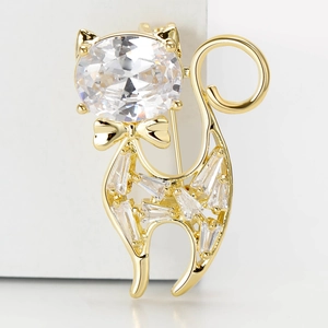 Elegant gold cat brooch with sparkling zircons and a cute bow tie on white background