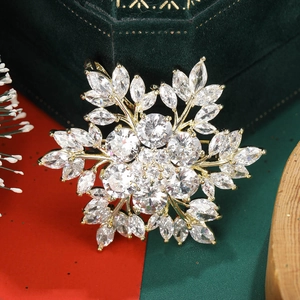 Close-up of golden snowflake brooch with sparkling zircons on green velvet box