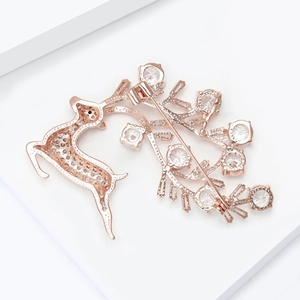 Detalle del broche de reno en oro rosa con circonitas brillantes y cierre de alfiler seguro