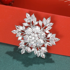 Macro shot of silver snowflake brooch with sparkling cubic zirconia on festive background