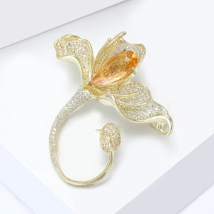 Détail de la broche magnolia avec pavé de zircons et pierre précieuse orange poire