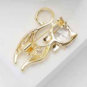 Elegant gold cat brooch with sparkling zircon crystal and pin clasp on white background