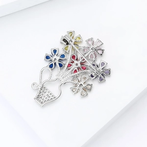 Detail view showing the secure pin clasp and hollow metal back of the colorful floral brooch