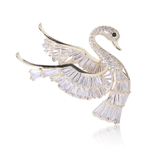 Detailed close-up of a luxury swan brooch with gold plating and sparkling baguette zircons