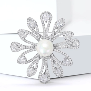 Macro shot of vintage floral brooch featuring center pearl and pear-cut crystal petals