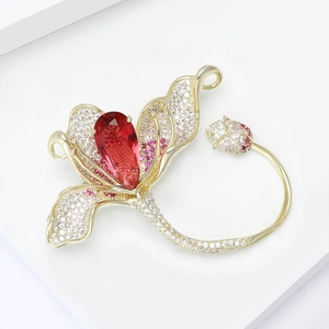 Détail de la broche fleur de magnolia avec cristal rouge poire et placage en or