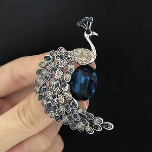 Detail view of silver peacock brooch with navy blue crystals and sparkling rhinestones