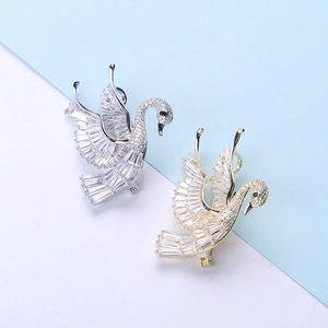 Detailed macro view of swan brooches featuring baguette-cut stones and pavé-set crystals