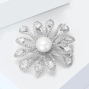 Macro shot of a floral pearl brooch with micro-pave cubic zirconia on a white platform