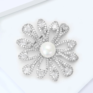 Detail of sunflower brooch with sparkling cubic zirconia and large freshwater pearl