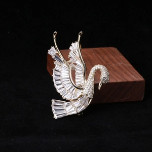 Detailed view of swan brooch with baguette-cut cubic zirconia and gold plating