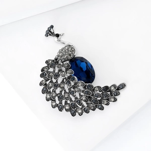 Elegant silver peacock brooch featuring dark blue crystal and sparkling rhinestones