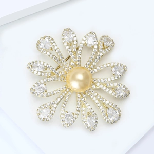 Macro shot of gold floral brooch with freshwater pearl and sparkling cubic zirconia stones