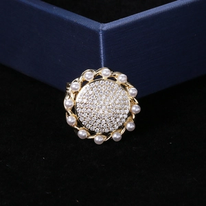 Detail of sunflower brooch with sparkling cubic zirconia, white pearls, and gold finish
