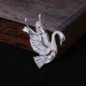 Macro shot of silver swan brooch with rectangle zircons and black gemstone eye detail