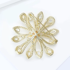 Macro detail of the golden flower brooch back showing safety pin and craftsmanship