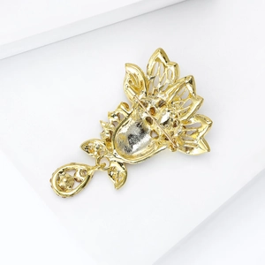 Vintage gold plated hollow flower brooch with teardrop pendant shown from a back view