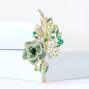 Detailed view of rose flower brooch with green crystals and fine zircon inlays