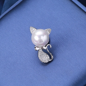Detailed close-up of a silver cat brooch featuring a large pearl head and zircon stones