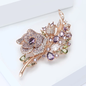 Close-up of rose gold flower brooch with micro-pave zircons and colorful gemstones